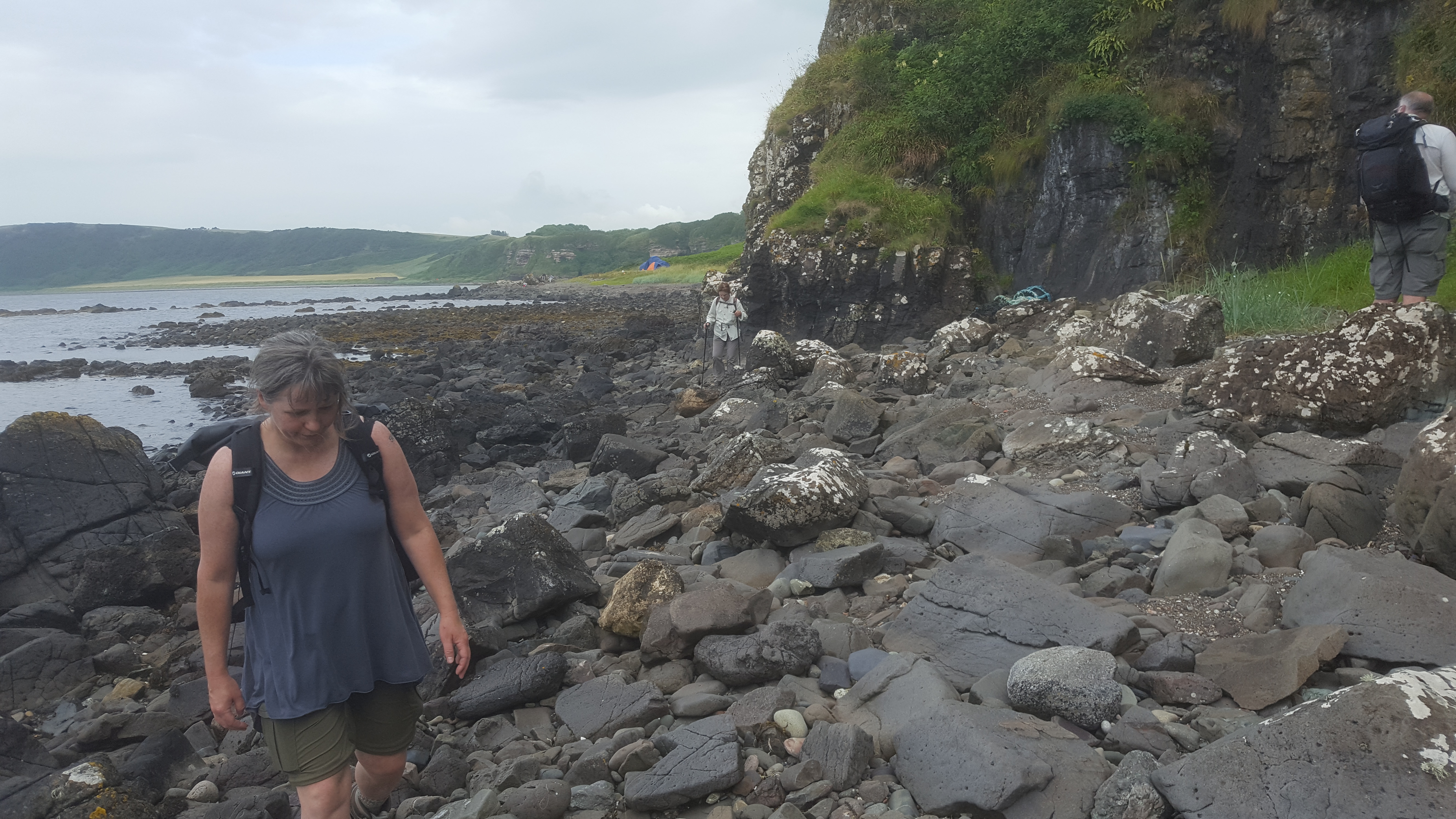 rock walking with campsite in background